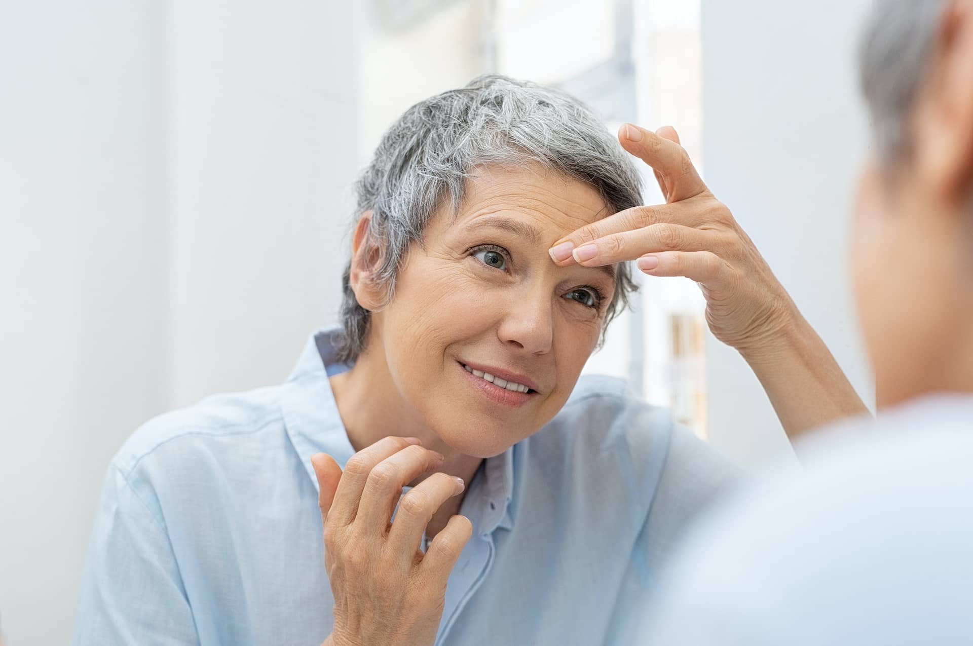 Mature woman looking her wrinkles face